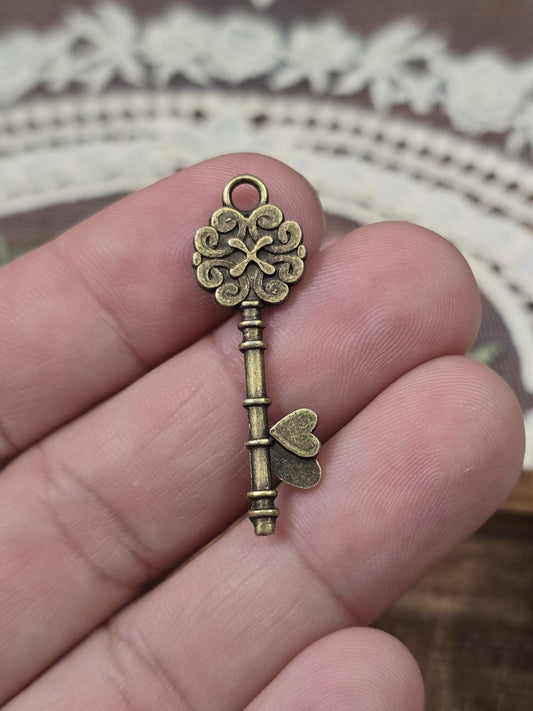Schlüssel-Anhänger 34x11mm in Bronze-Optik quer auf Fingern gehalten als Größenvergleich.