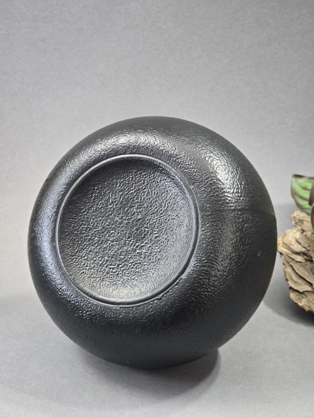 Bodenansicht der schwarzen runden Vase mit Standfläche und strukturierter Oberfläche zur Dokumentation der Form