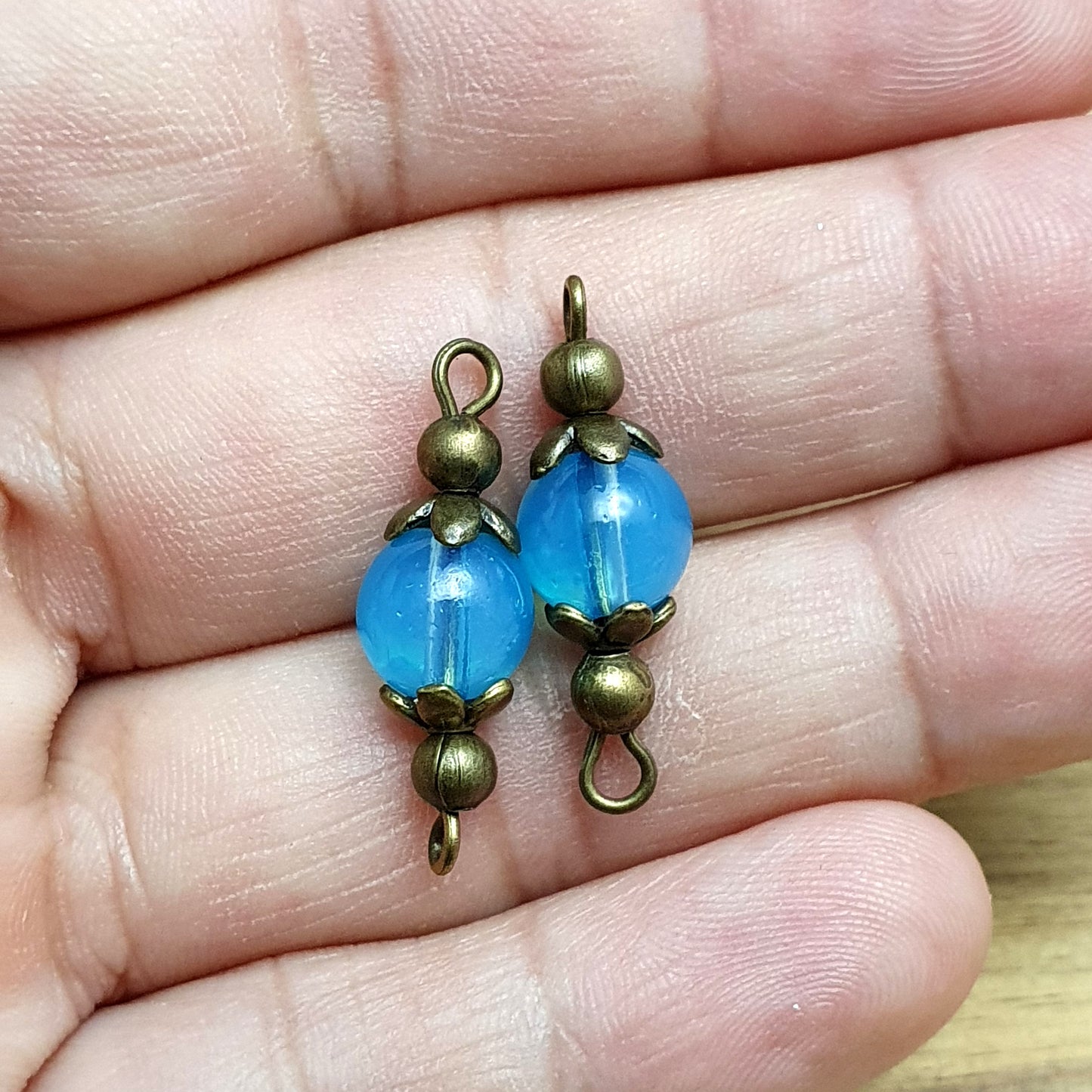 2 handgemachte Verbinder mit transparenten blauen Glasperlen, 24mm, antik bronzefarbig