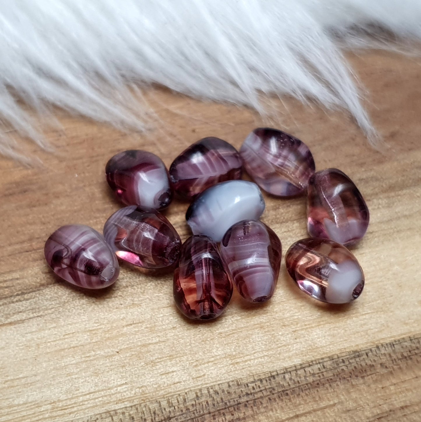 10 amethystfarbene Glasperlen aus Gablonz in nuggetform, 7,5mm, mit weißen Akzenten