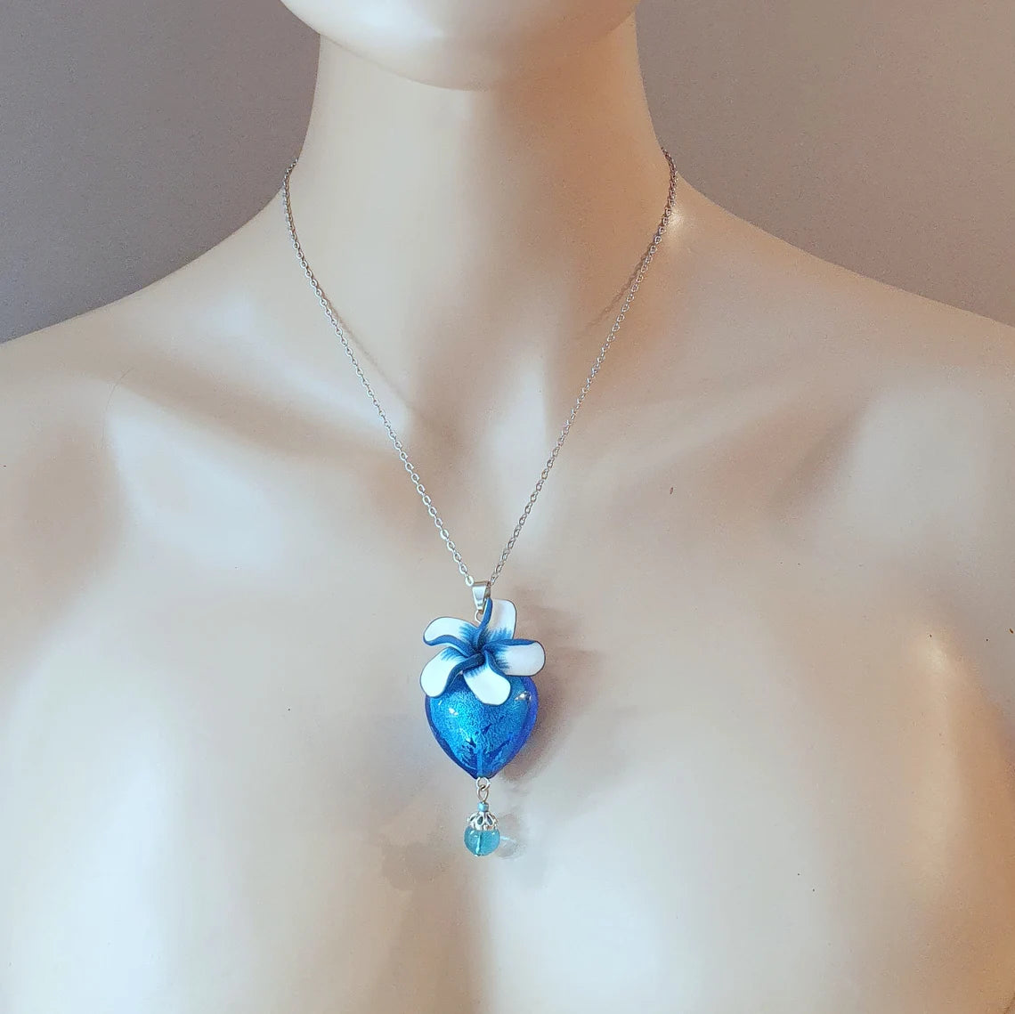 Anhänger Herz aus blauem Glas, mit Blüte aus Fimo, an Edelstahlkette