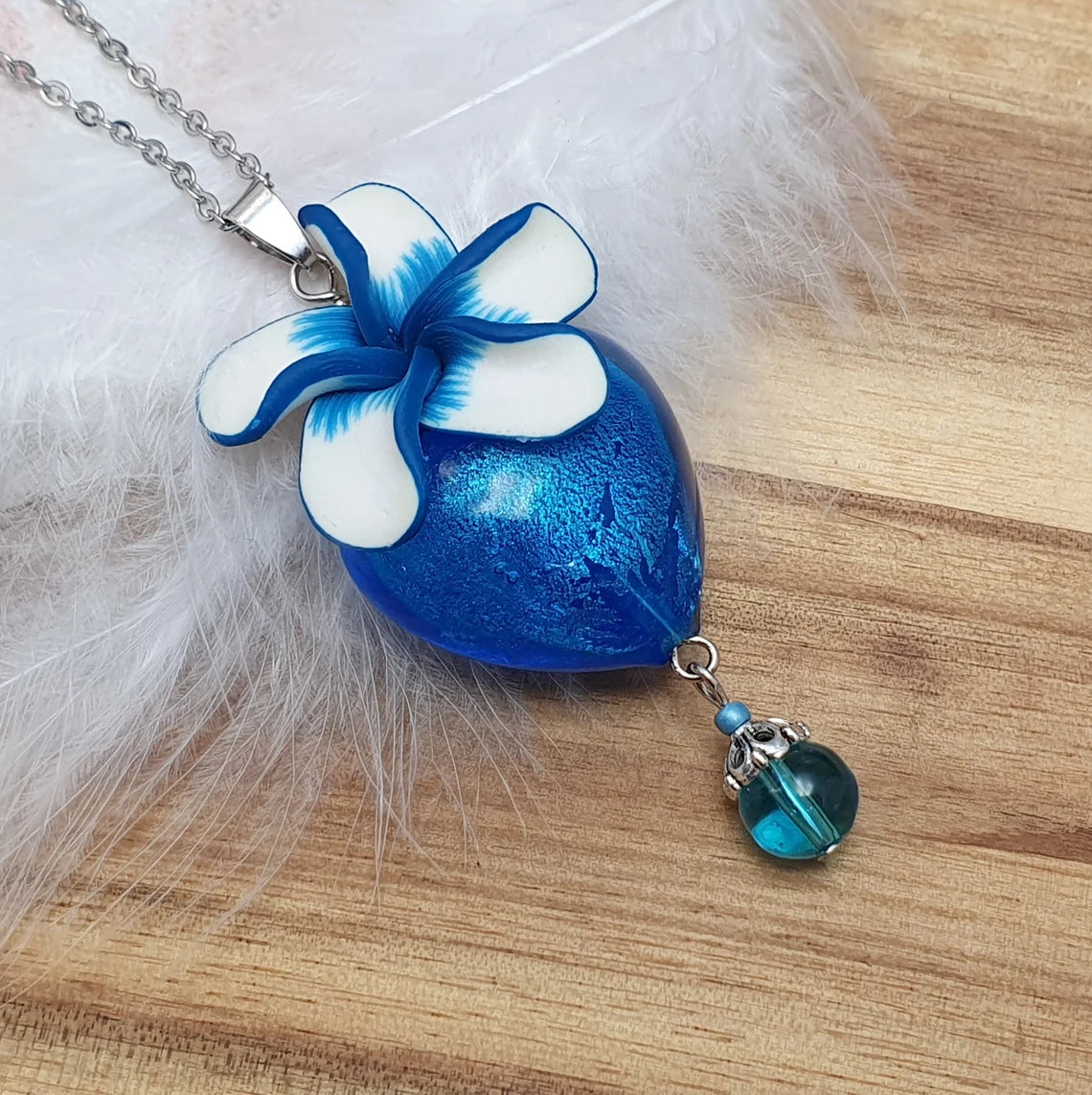 Anhänger Herz aus blauem Glas, mit Blüte aus Fimo, an Edelstahlkette
