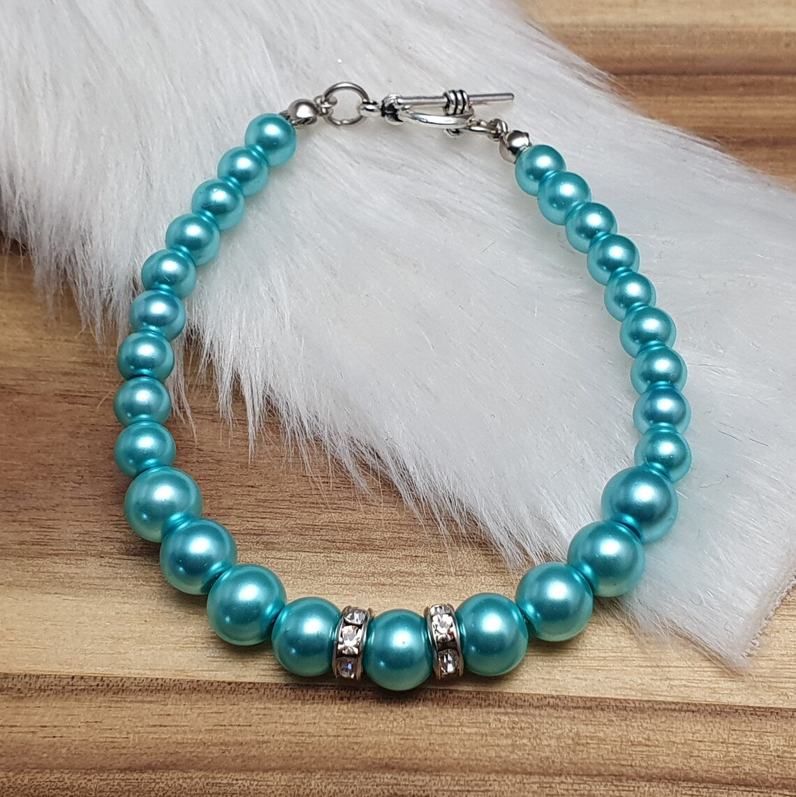 Armband aus aquablauen Glaswachsperlen mit Strassrondellen