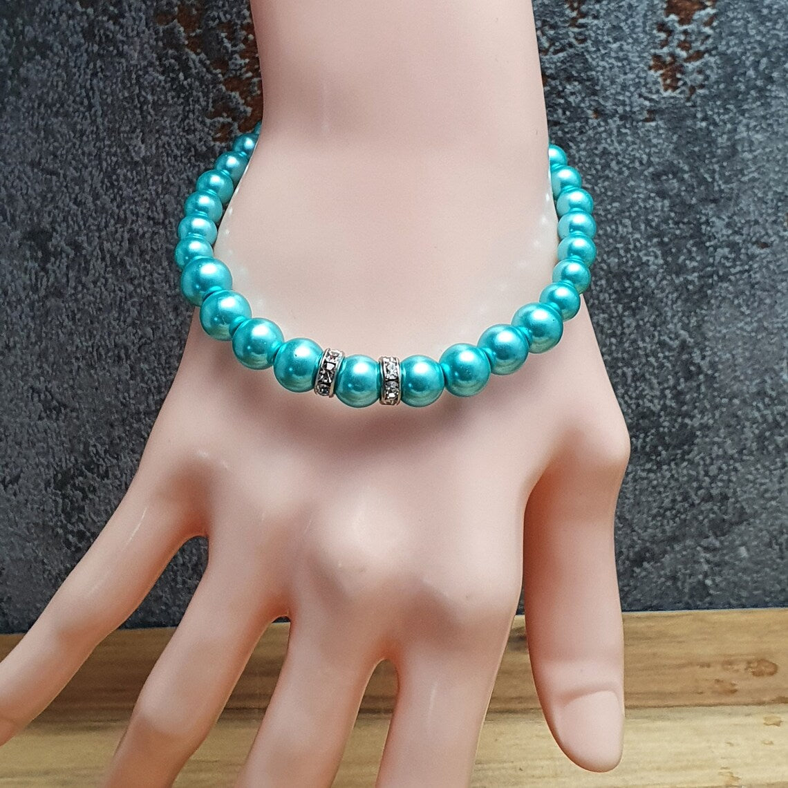 Armband aus aquablauen Glaswachsperlen mit Strassrondellen