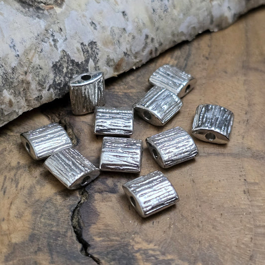 10 antiksilberfarbene Metallperlen in Kissenform, 8 x 8 mm, mit strukturierter Oberfläche. Ideal für Schmuckdesigns wie Ketten, Armbänder oder kreative Dekorationen. Sie setzen stilvolle Akzente in jedem Projekt.