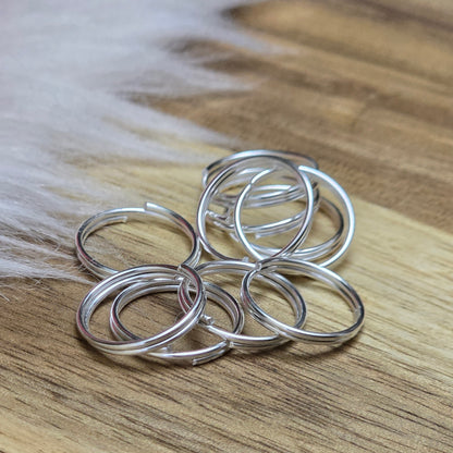 Das Bild zeigt 10 doppelte Binderinge in versilbert mit einem Durchmesser von 12mm. Die Verbindungsringe sind ein unverzichtbares Zubehör für die Schmuckherstellung. Durch ihre doppelte Wicklung bieten sie eine besonders stabile und sichere Verbindung, sodass Anhänger, Charms und Verschlüsse zuverlässig befestigt bleiben.