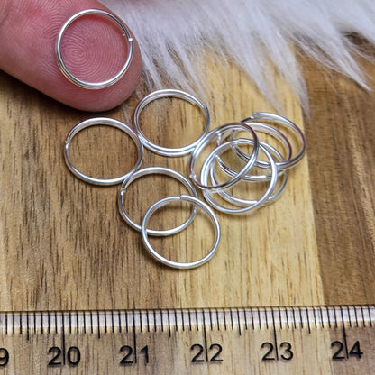 Das Bild zeigt 10 doppelte Binderinge in versilbert mit einem Durchmesser von 12mm. Die Verbindungsringe sind ein unverzichtbares Zubehör für die Schmuckherstellung. Durch ihre doppelte Wicklung bieten sie eine besonders stabile und sichere Verbindung, sodass Anhänger, Charms und Verschlüsse zuverlässig befestigt bleiben.