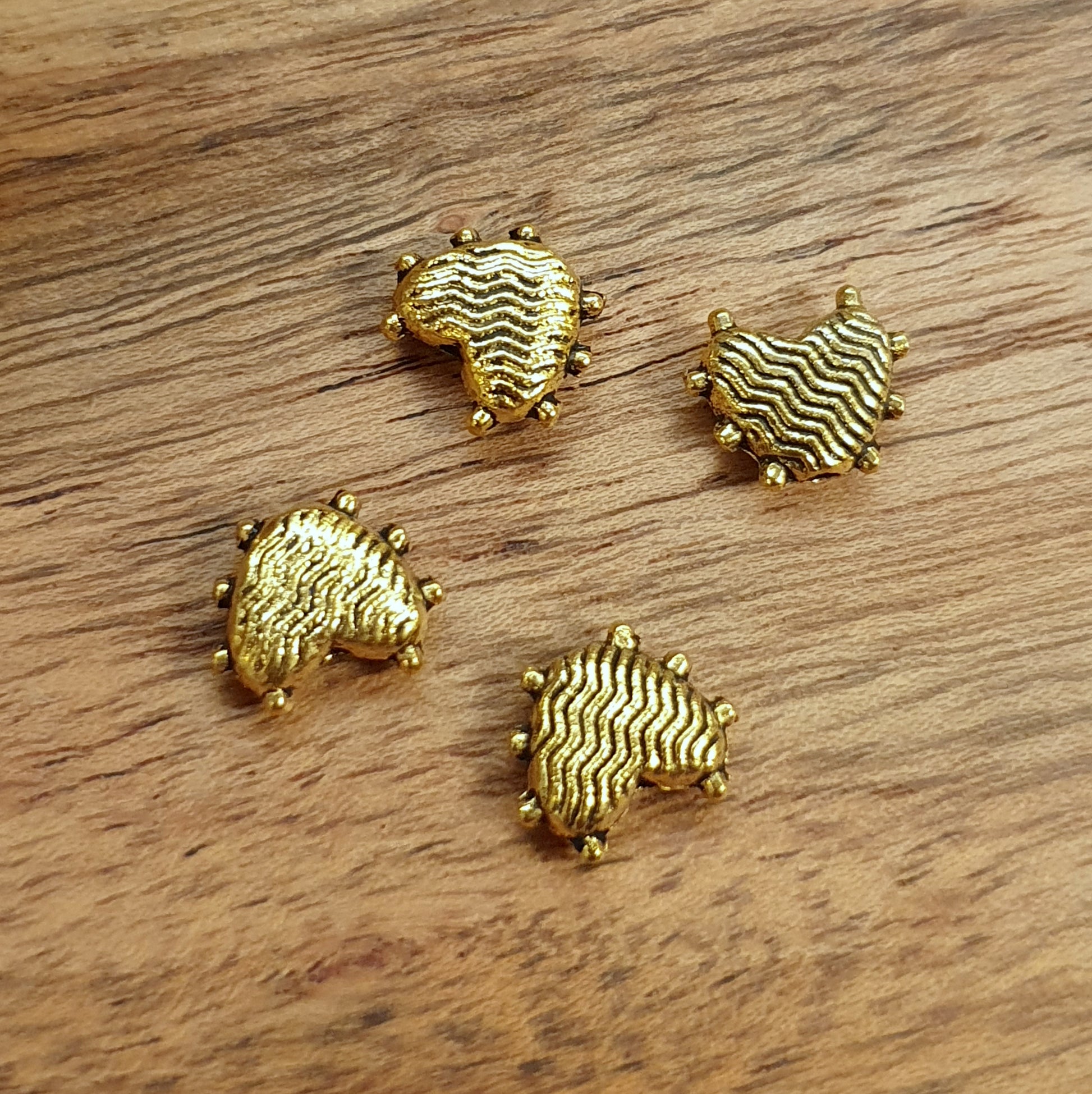 4 Metallperlen Herz Waves, 8mm, antik goldfarbig