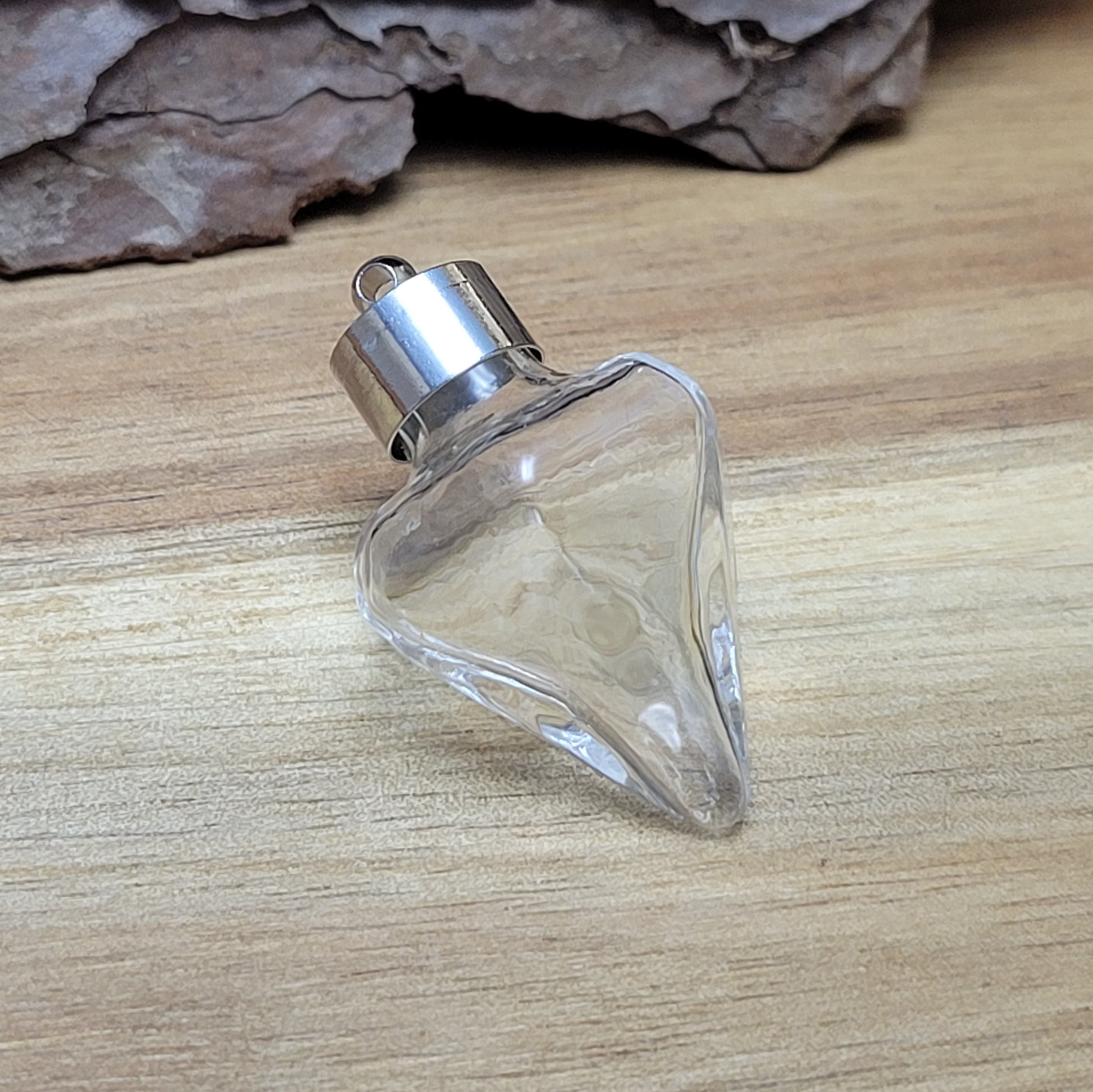 Anhänger Glasflasche in konischer Form, ideal zum befüllen.  Die Glasflasche hat eine nach unten spitz zulaufende Form mit sechs flachen Seiten und einer Öffnung oben. Diese Öffnung bietet Platz für eine Vielzahl von Materialien, darunter Edelsteinsplitter, Sand, Glitzer, Granulat und sogar Flüssigkeiten (bitte beachten Sie die Öffnungsgröße).