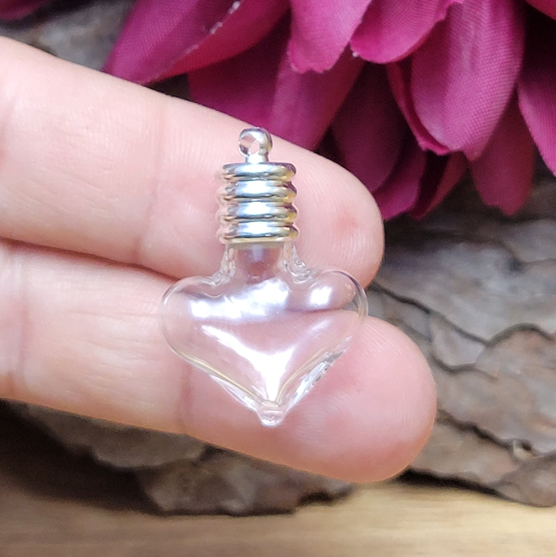 Anhänger kleine Glasflasche in Form eines Herzens zum befüllen.  Die Glasflasche hat oben eine Öffnung oben und bietet Platz für eine Vielzahl von Materialien, darunter (wirklich kleine) Edelsteinsplitter, Sand, Glitzer, und Granulat (bitte beachten Sie die Öffnungsgröße). 