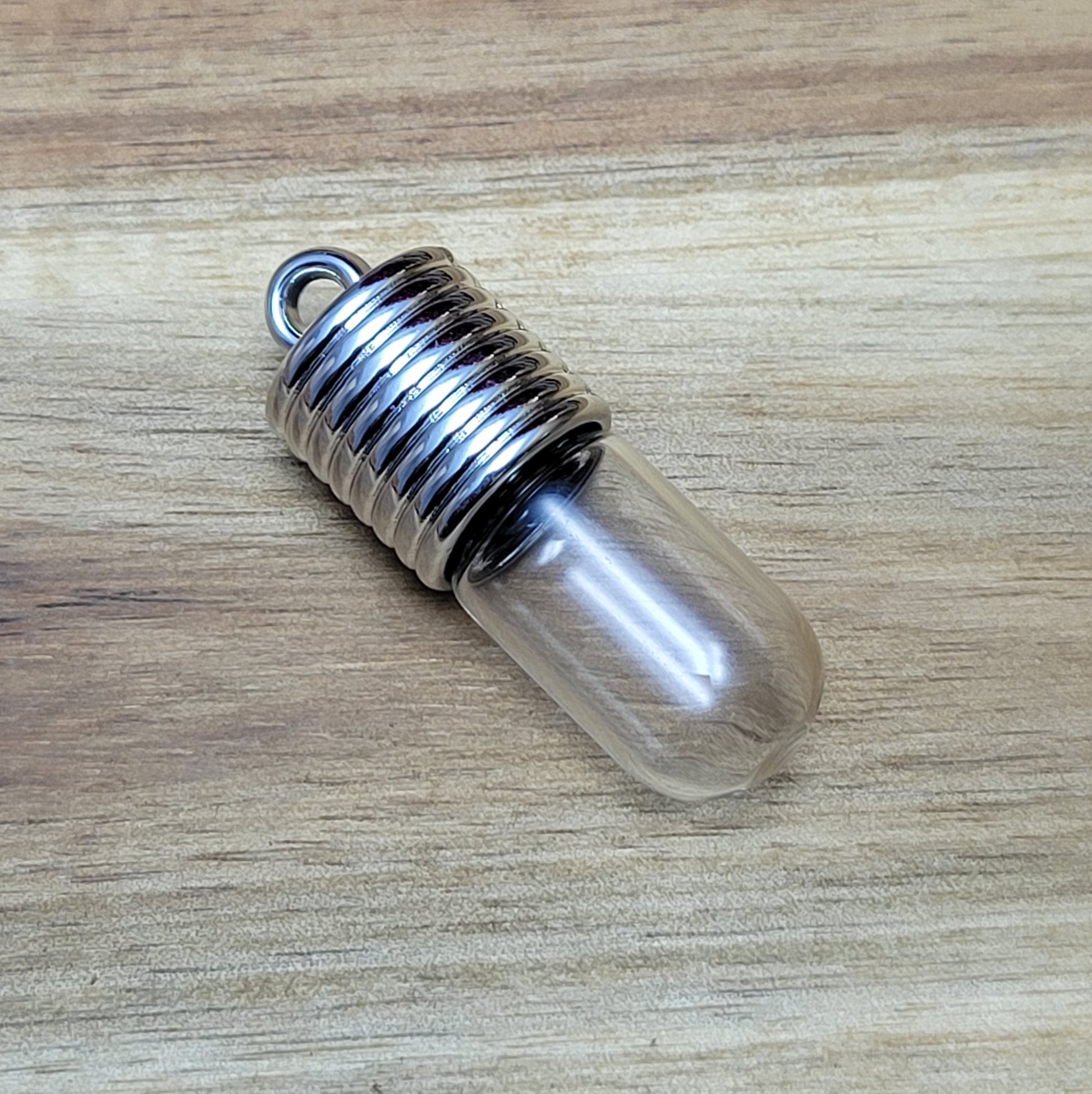 Anhänger Glasflasche mit rundem Boden zum selber befüllen.  Die Glasflasche hat oben eine "große" Öffnung und bietet Platz für eine Vielzahl von Erinnerungen und Materialien wie Edelsteinsplitter, Sand, Glitzer, Granulat, Tierhaare, Milchzähne, kleine Turmdeckelschnecken etc. (bitte beachten Sie die Öffnungsgröße). 