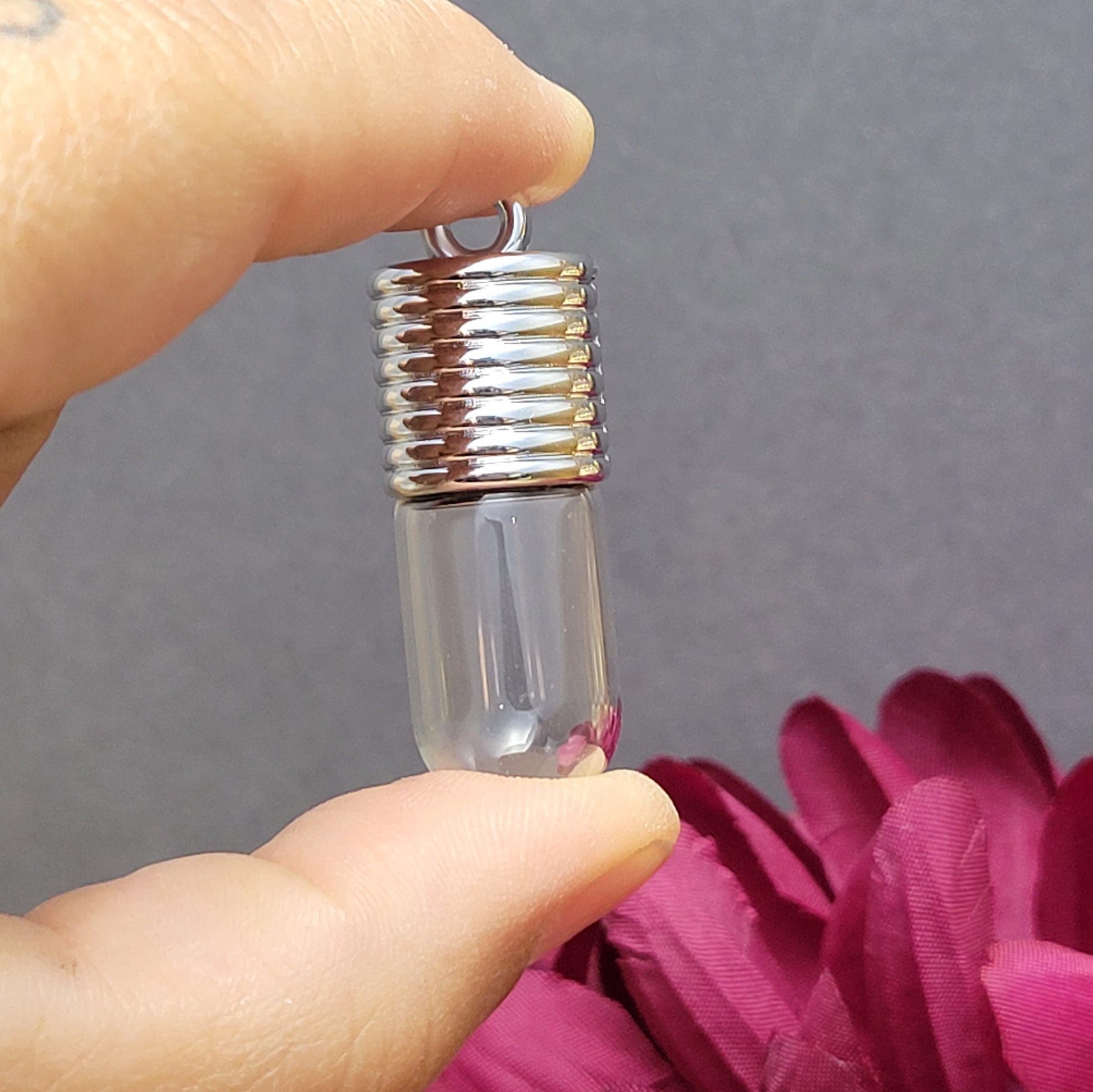 Anhänger Glasflasche mit rundem Boden zum selber befüllen.  Die Glasflasche hat oben eine "große" Öffnung und bietet Platz für eine Vielzahl von Erinnerungen und Materialien wie Edelsteinsplitter, Sand, Glitzer, Granulat, Tierhaare, Milchzähne, kleine Turmdeckelschnecken etc. (bitte beachten Sie die Öffnungsgröße). 