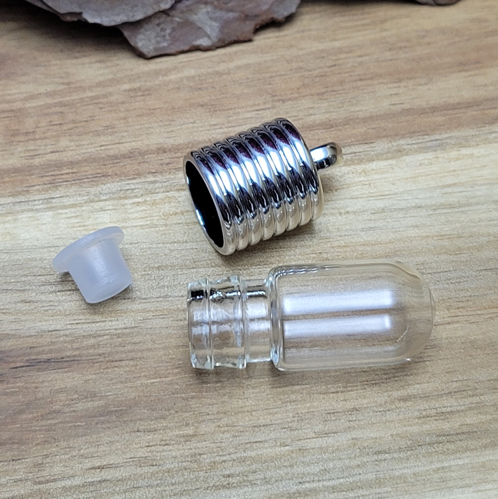 Anhänger Glasflasche mit rundem Boden zum selber befüllen.  Die Glasflasche hat oben eine "große" Öffnung und bietet Platz für eine Vielzahl von Erinnerungen und Materialien wie Edelsteinsplitter, Sand, Glitzer, Granulat, Tierhaare, Milchzähne, kleine Turmdeckelschnecken etc. (bitte beachten Sie die Öffnungsgröße). 