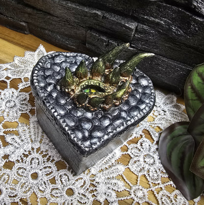 Das Bild zeigt eine mystische Drachen Schmuckschatulle, Ladebox aus Holz, für Fantasy Fairycore

Diese mystische Drachen-Schmuckschatulle in Herzform ist ein wahres Meisterwerk der Magie und Fantasie.