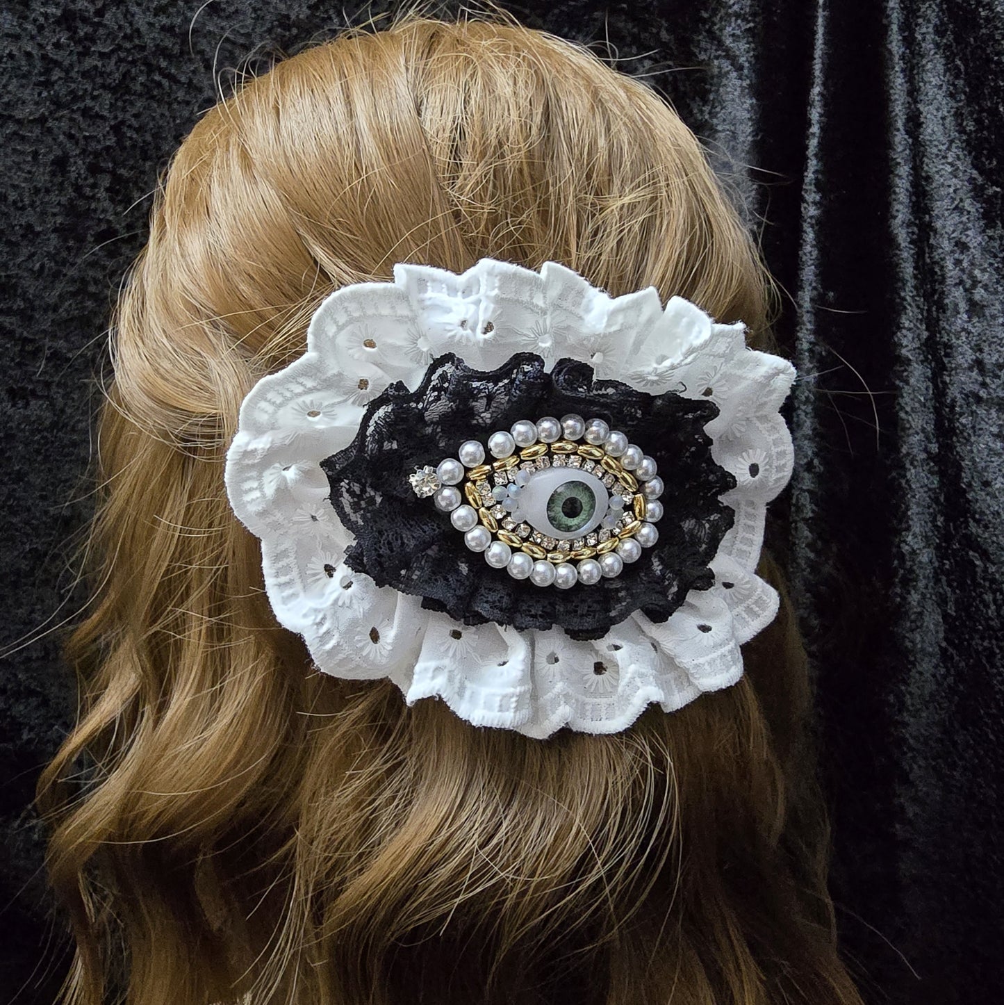 Das Bild zeigt eine tolle Haarspange Auge mit romantischer weiße Rüsche

Die Haarspange, die dich (und alle anderen) im Auge behält 👁️
Diese Haarspange ist nicht nur ein Accessoire – sie ist ein Gesprächsstarter! Mit ihrem mystischen Auge, umrahmt von Strass, goldfarbigen und weißen Kunststoffperlen sowie einer romantischen schwarzen und weißen Rüschen, kombiniert sie einen Hauch von Gothic-Chic mit einer Prise Kurioses.