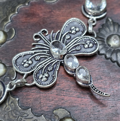 Nahaufnahme eines Armbands aus .925 Silber mit einer filigranen Libelle und Zirkoniasteinen, versehen mit einem Toggle-Verschluss, ca. 4,9 x 4,2 cm Länge.