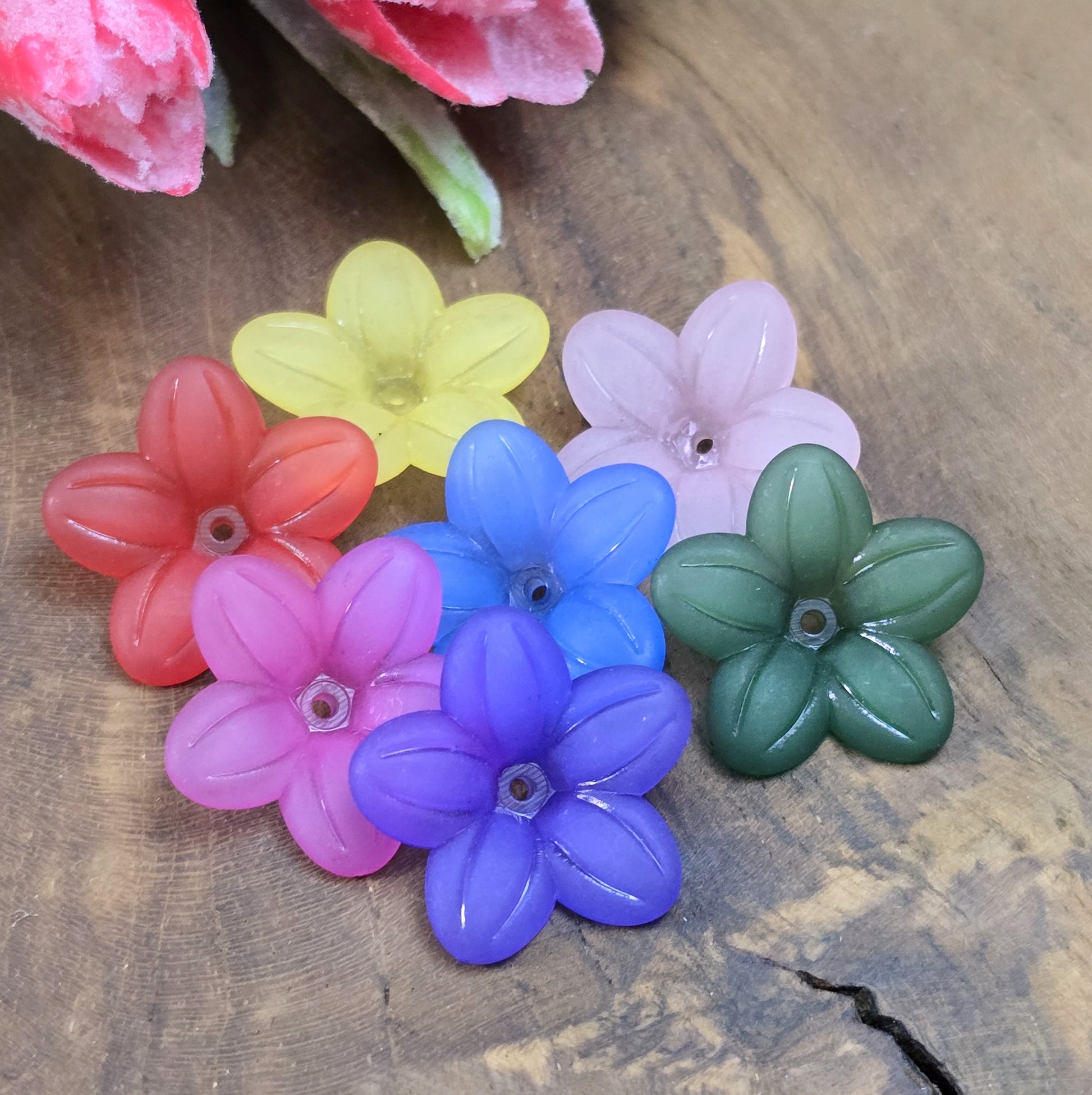 Ein Set aus 30 dekorativen Blumenperlen aus Acryl im bunten Farbmix. Die Perlen sind 2,2 cm groß und mit 5 stilisierten Blütenblättern gestaltet. Dank des zentralen Lochs lassen sich die Perlen mühelos auffädeln und vielseitig verwenden.