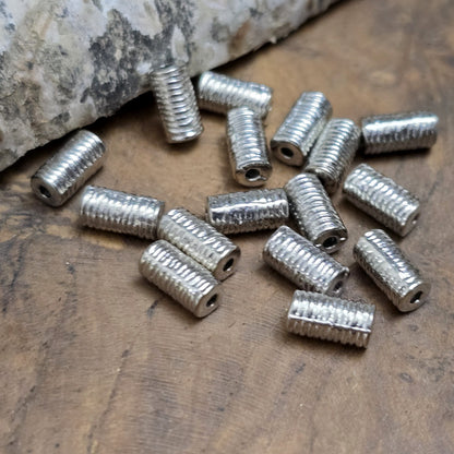16 Metallperlen in Walzenform – Antiksilberfarben, mit feiner Struktur, 7 mm

Diese kleinen, länglich-runden Metallperlen mit antikem Finish verleihen deinen Schmuckprojekten eine elegante und vielseitige Note. Perfekt geeignet als Abstandhalter oder dezente Akzente, sorgen sie für das gewisse Etwas in deinen Kreationen.