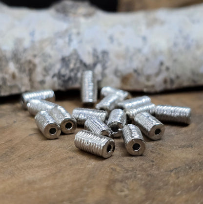 16 Metallperlen in Walzenform – Antiksilberfarben, mit feiner Struktur, 7 mm

Diese kleinen, länglich-runden Metallperlen mit antikem Finish verleihen deinen Schmuckprojekten eine elegante und vielseitige Note. Perfekt geeignet als Abstandhalter oder dezente Akzente, sorgen sie für das gewisse Etwas in deinen Kreationen.