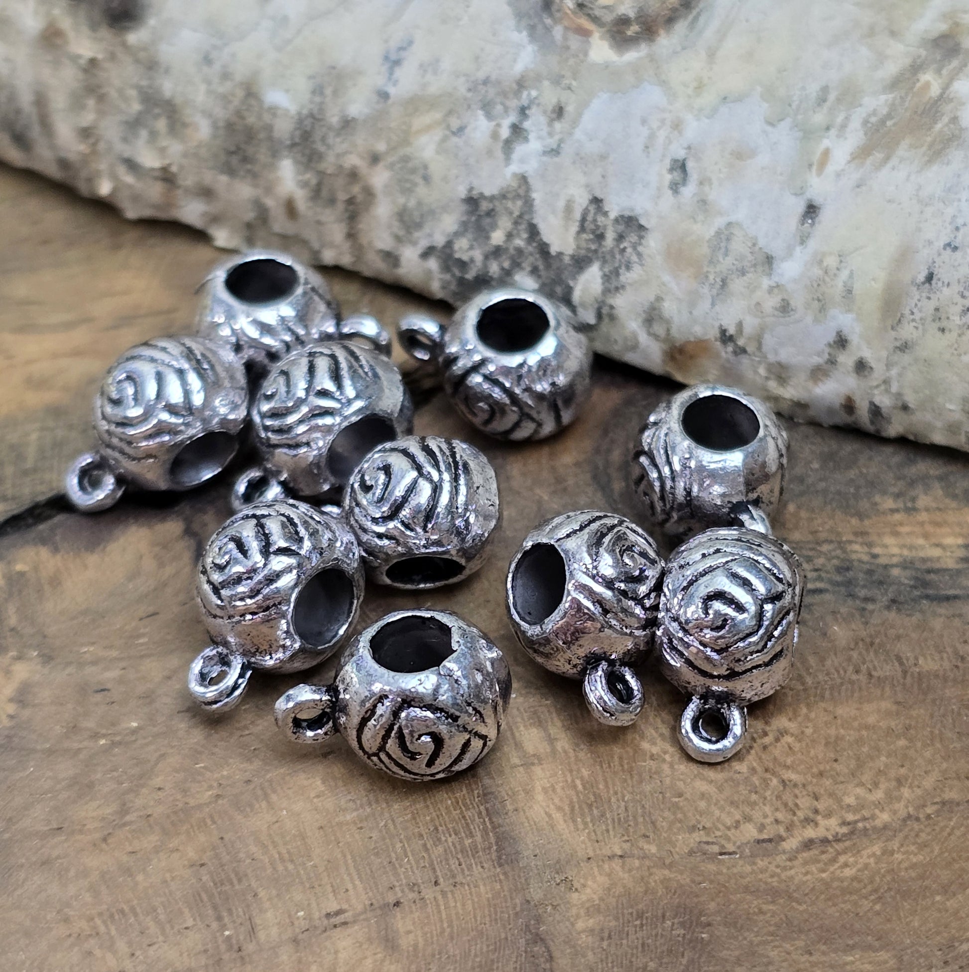 10 runde Metallperlen in Antiksilber mit Rosenmotiv und großer Öse. Größe: 8 x 12 mm, Fädelloch: 4 mm. Perfekt für Armbänder, Ketten und zum Befestigen kleiner Anhänger. Ideal für romantische Schmuckdesigns und traditionelle Kreationen.