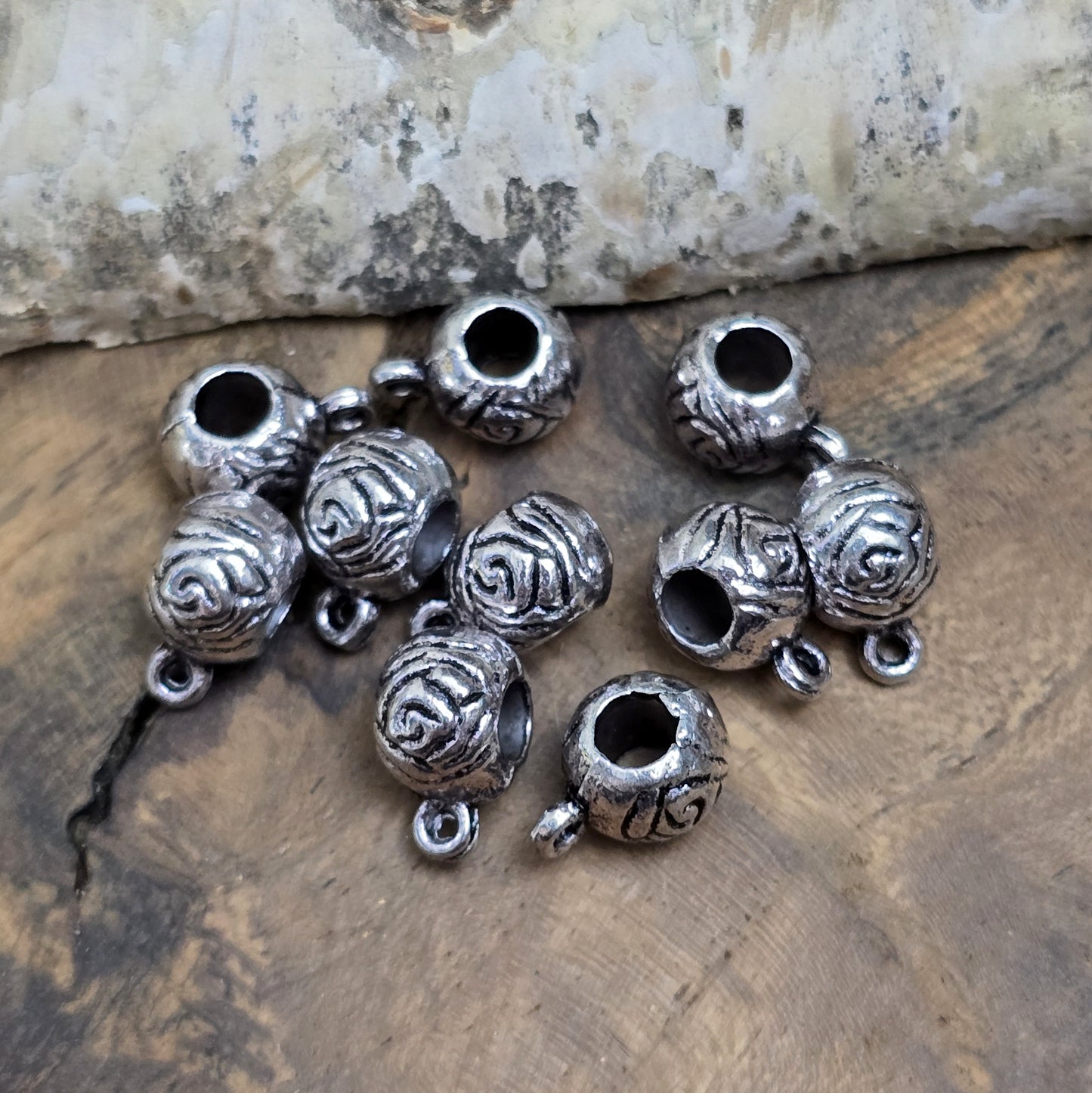 10 runde Metallperlen in Antiksilber mit Rosenmotiv und großer Öse. Größe: 8 x 12 mm, Fädelloch: 4 mm. Perfekt für Armbänder, Ketten und zum Befestigen kleiner Anhänger. Ideal für romantische Schmuckdesigns und traditionelle Kreationen.