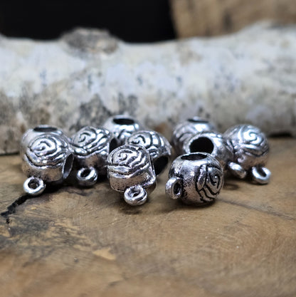 10 runde Metallperlen in Antiksilber mit Rosenmotiv und großer Öse. Größe: 8 x 12 mm, Fädelloch: 4 mm. Perfekt für Armbänder, Ketten und zum Befestigen kleiner Anhänger. Ideal für romantische Schmuckdesigns und traditionelle Kreationen.