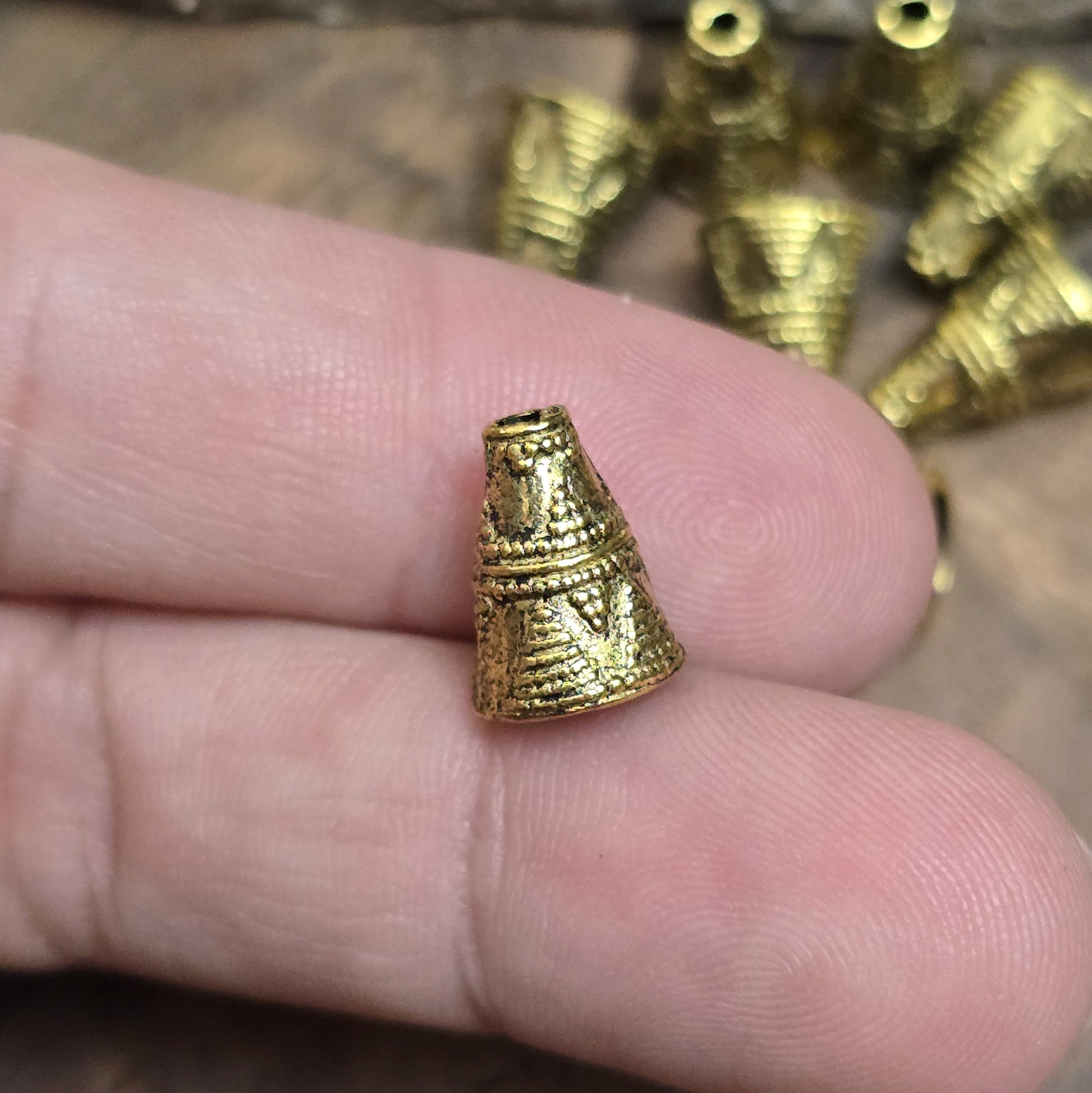 4 konische Kappen aus Metall, Ethnodesign, 11x8mm, antik goldfarbig

Diese konischen Kappen aus Metall bieten einen stilvollen Abschluss für Perlen, Ketten oder Armbänder. Sie sind auch ideal, um Perlen vor dem Anstoßen zu schützen und verleihen deinem Schmuck oder Accessoire eine geheimnisvolle Note.