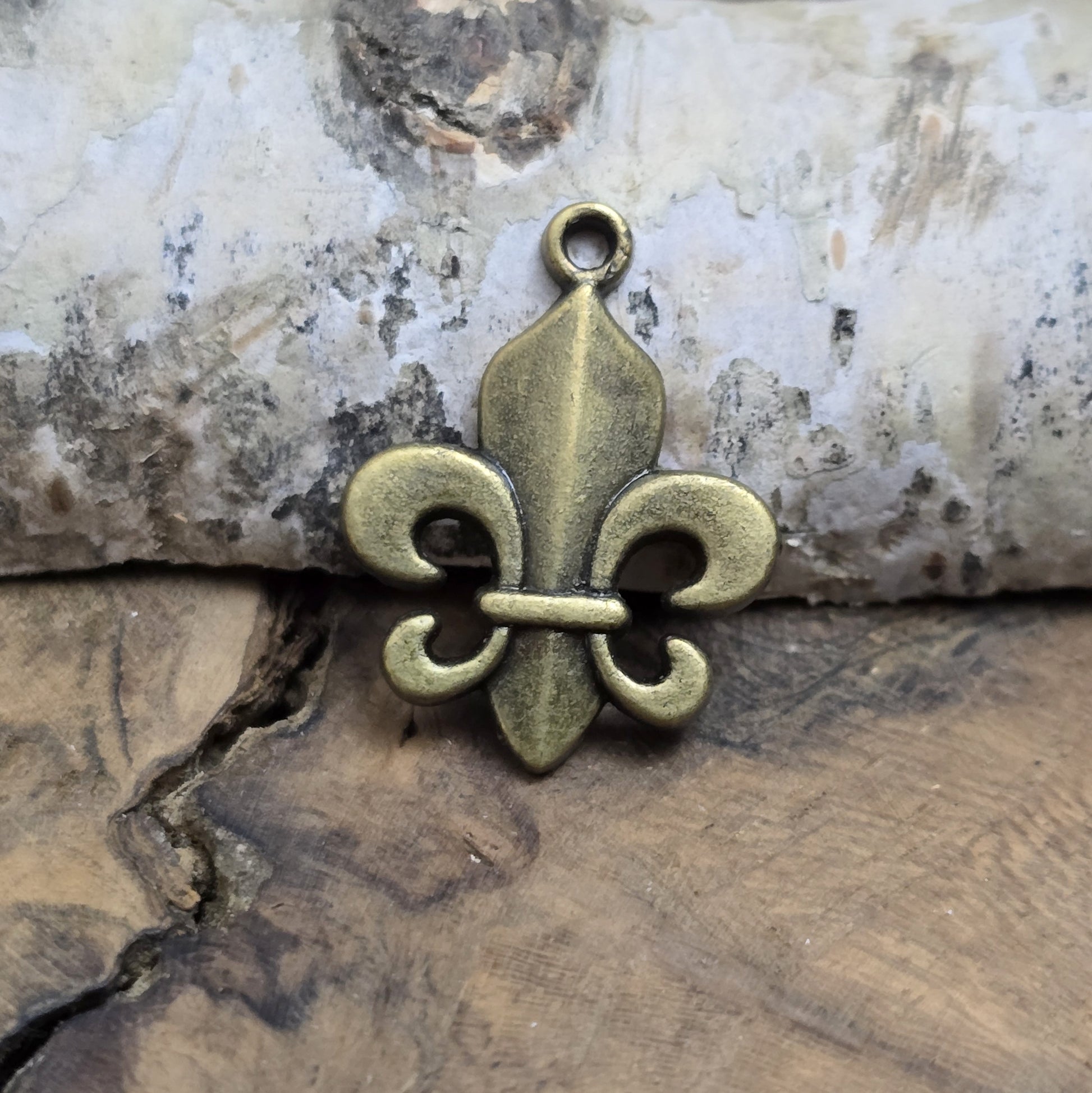 Das Bild zeigt 3 Anhänger Fleur de Lys 22mm, antik bronzefarbig. Ideal für die individuelle Schmuckfertigung.