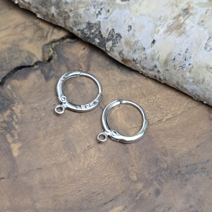 Das Bild zeigt Creolen mit Anhängeröse. Sie sind exquisite Schmuckstücke, die aus 925er Silber gefertigt sind. Mit einem Durchmesser von 13 mm (außen) sind sie elegant und perfekt für den täglichen Gebrauch oder besondere Anlässe.
