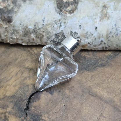 Anhänger Glasflasche in konischer Form, ideal zum befüllen.  Die Glasflasche hat eine nach unten spitz zulaufende Form mit sechs flachen Seiten und einer Öffnung oben. Diese Öffnung bietet Platz für eine Vielzahl von Materialien, darunter Edelsteinsplitter, Sand, Glitzer, Granulat und sogar Flüssigkeiten (bitte beachten Sie die Öffnungsgröße).