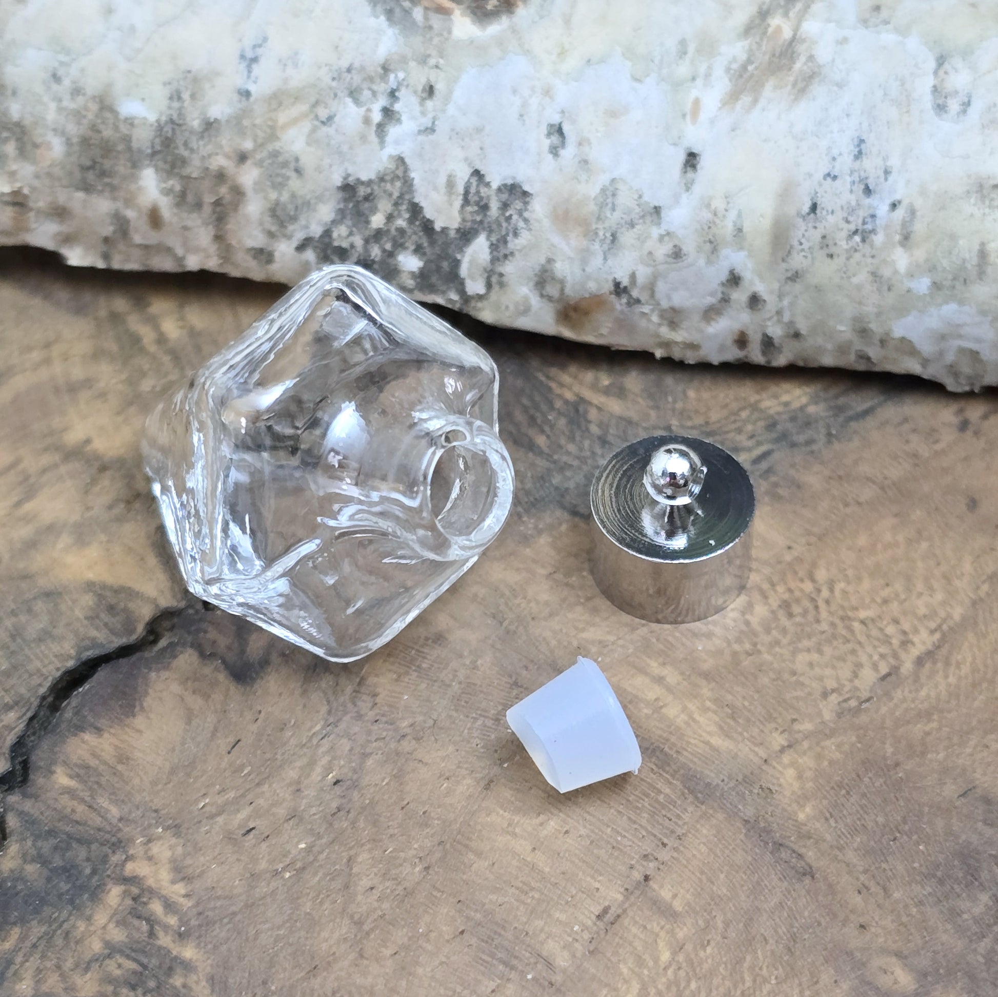 Anhänger Glasflasche in konischer Form, ideal zum befüllen.  Die Glasflasche hat eine nach unten spitz zulaufende Form mit sechs flachen Seiten und einer Öffnung oben. Diese Öffnung bietet Platz für eine Vielzahl von Materialien, darunter Edelsteinsplitter, Sand, Glitzer, Granulat und sogar Flüssigkeiten (bitte beachten Sie die Öffnungsgröße).