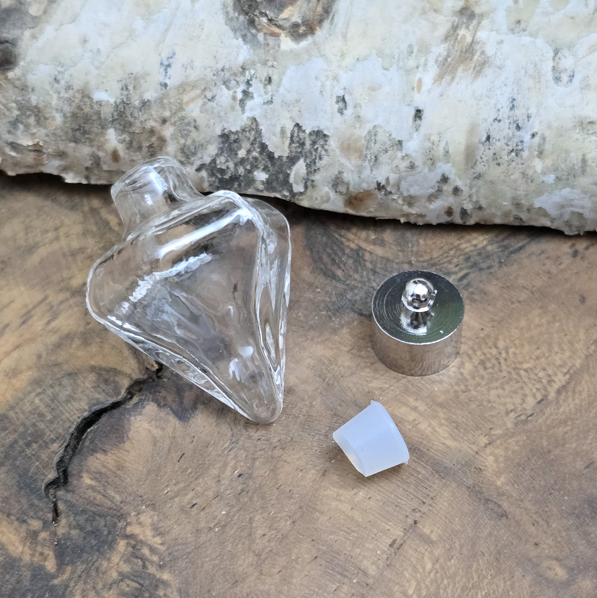 Anhänger Glasflasche in konischer Form, ideal zum befüllen.  Die Glasflasche hat eine nach unten spitz zulaufende Form mit sechs flachen Seiten und einer Öffnung oben. Diese Öffnung bietet Platz für eine Vielzahl von Materialien, darunter Edelsteinsplitter, Sand, Glitzer, Granulat und sogar Flüssigkeiten (bitte beachten Sie die Öffnungsgröße).