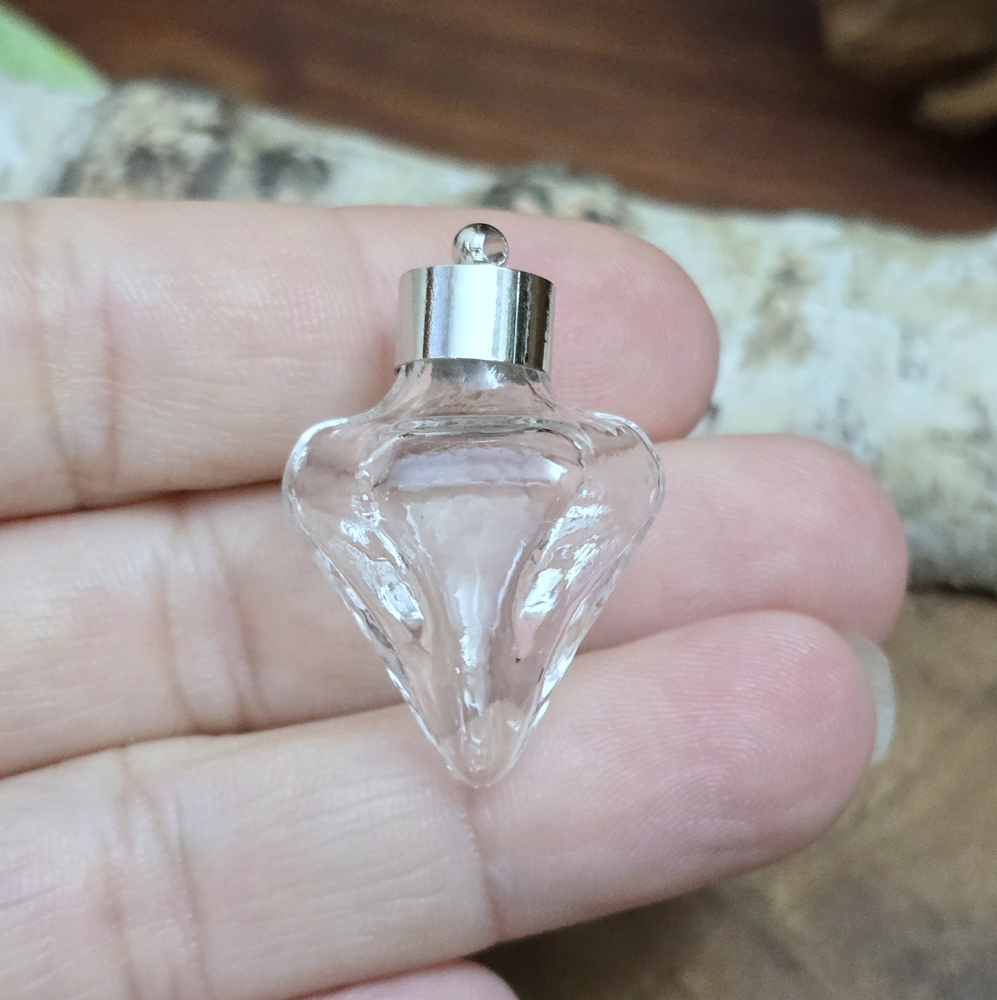 Anhänger Glasflasche in konischer Form, ideal zum befüllen.  Die Glasflasche hat eine nach unten spitz zulaufende Form mit sechs flachen Seiten und einer Öffnung oben. Diese Öffnung bietet Platz für eine Vielzahl von Materialien, darunter Edelsteinsplitter, Sand, Glitzer, Granulat und sogar Flüssigkeiten (bitte beachten Sie die Öffnungsgröße).