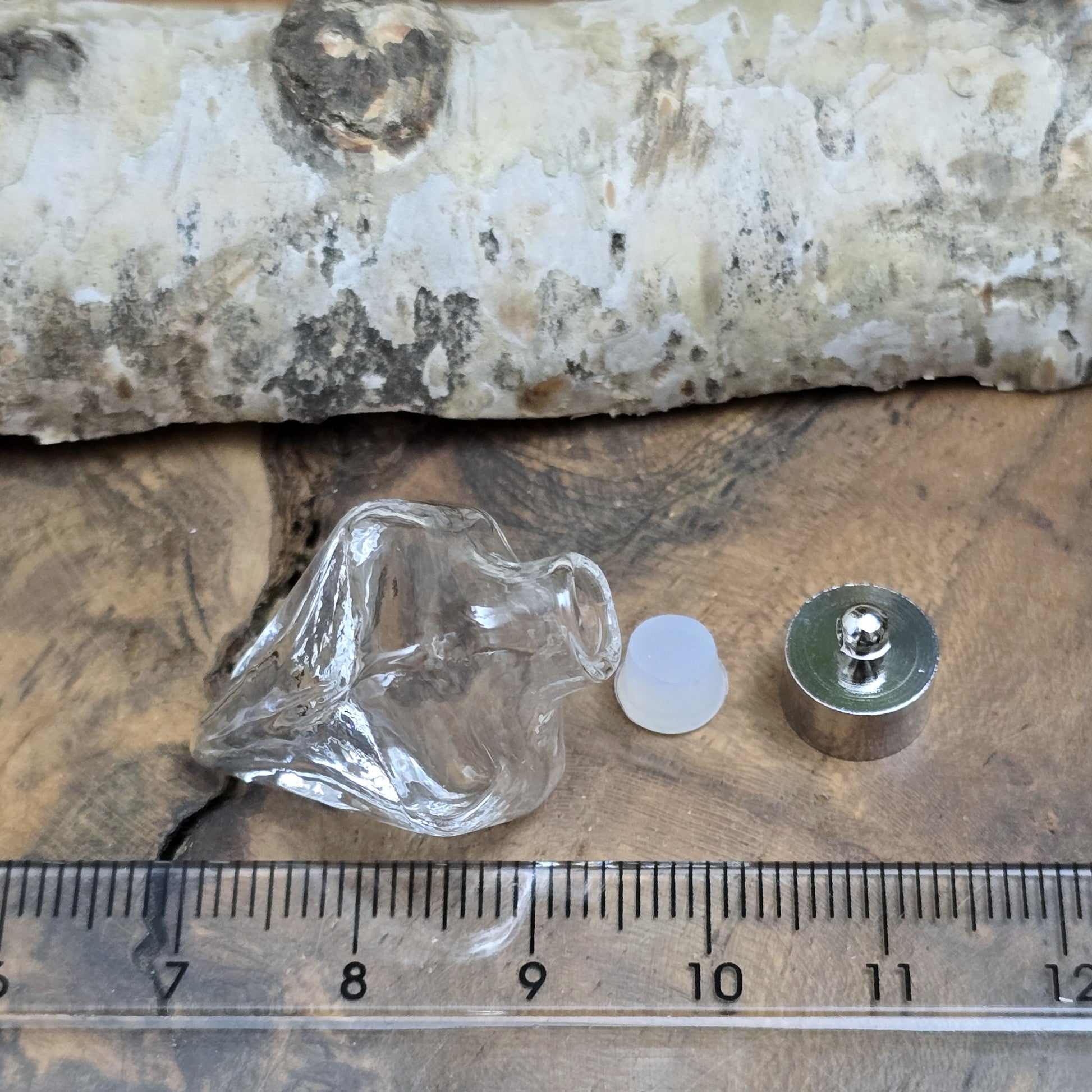 Anhänger Glasflasche in konischer Form, ideal zum befüllen.  Die Glasflasche hat eine nach unten spitz zulaufende Form mit sechs flachen Seiten und einer Öffnung oben. Diese Öffnung bietet Platz für eine Vielzahl von Materialien, darunter Edelsteinsplitter, Sand, Glitzer, Granulat und sogar Flüssigkeiten (bitte beachten Sie die Öffnungsgröße).