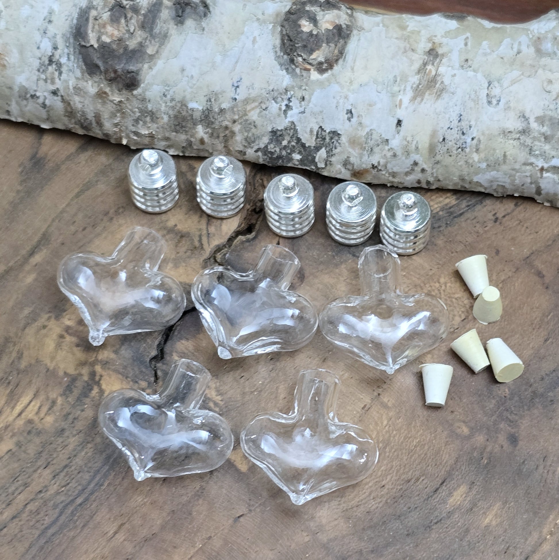 Kleiner Phiolenanhänger aus Glas, in Form eines Herzens mit silberfarbiger Kappe. Ideal zum Befüllen mit beschriftetem Reiskorn, Sand, Milchzahn, Asche, Haare udg.