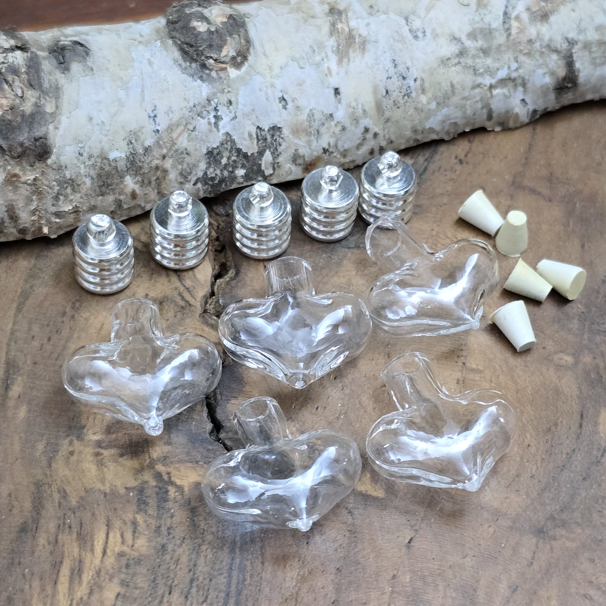 Kleiner Phiolenanhänger aus Glas, in Form eines Herzens mit silberfarbiger Kappe. Ideal zum Befüllen mit beschriftetem Reiskorn, Sand, Milchzahn, Asche, Haare udg.