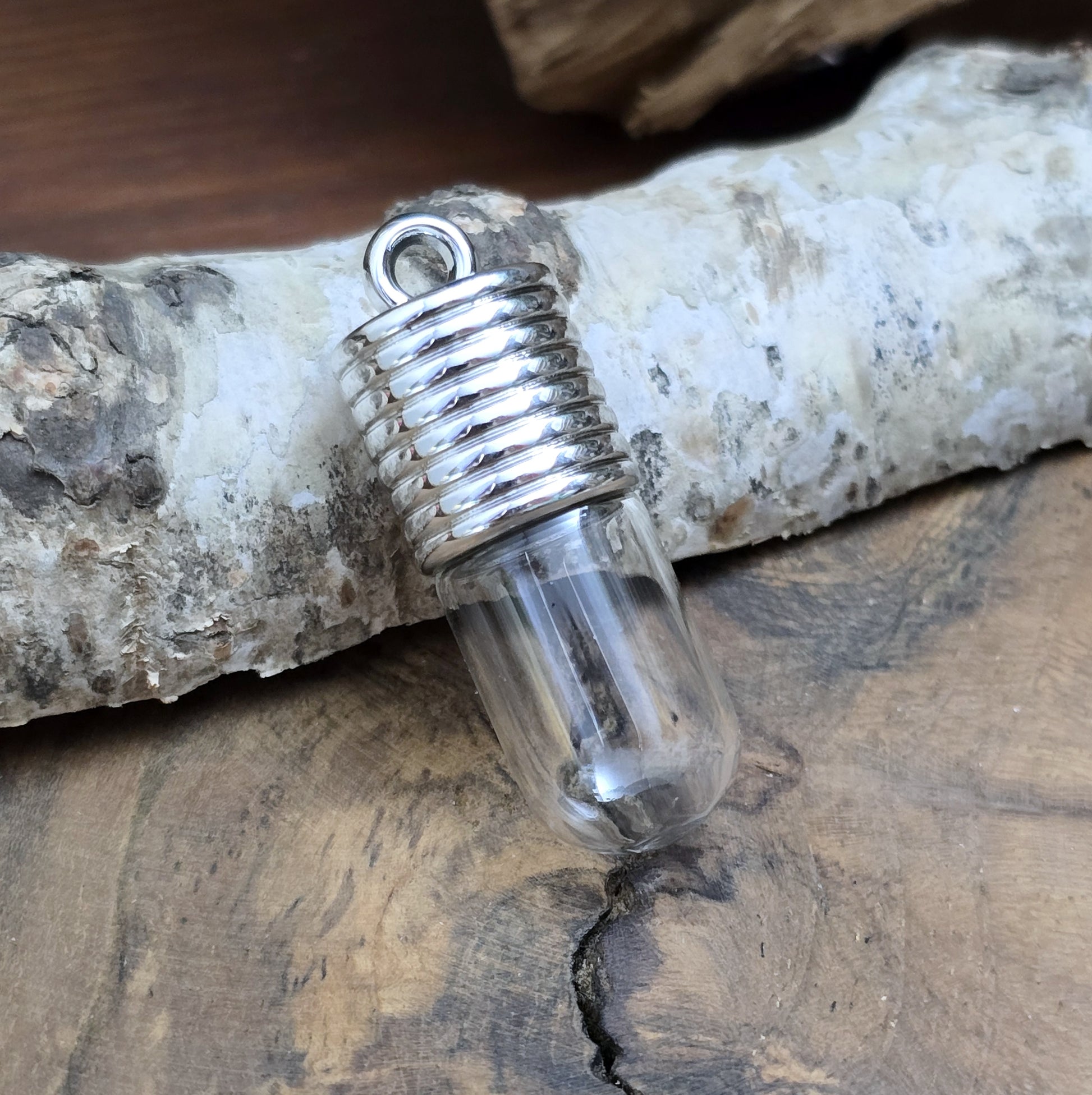 Anhänger Glasflasche mit rundem Boden zum selber befüllen.  Die Glasflasche hat oben eine "große" Öffnung und bietet Platz für eine Vielzahl von Erinnerungen und Materialien wie Edelsteinsplitter, Sand, Glitzer, Granulat, Tierhaare, Milchzähne, kleine Turmdeckelschnecken etc. (bitte beachten Sie die Öffnungsgröße). 