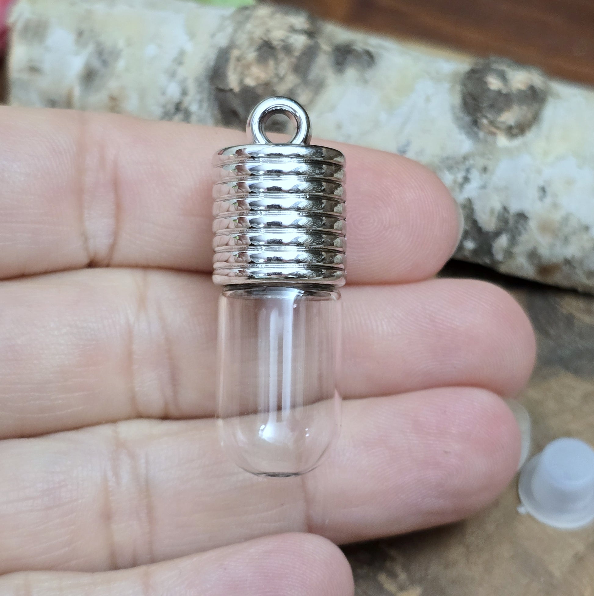 Anhänger Glasflasche mit rundem Boden zum selber befüllen.  Die Glasflasche hat oben eine "große" Öffnung und bietet Platz für eine Vielzahl von Erinnerungen und Materialien wie Edelsteinsplitter, Sand, Glitzer, Granulat, Tierhaare, Milchzähne, kleine Turmdeckelschnecken etc. (bitte beachten Sie die Öffnungsgröße). 