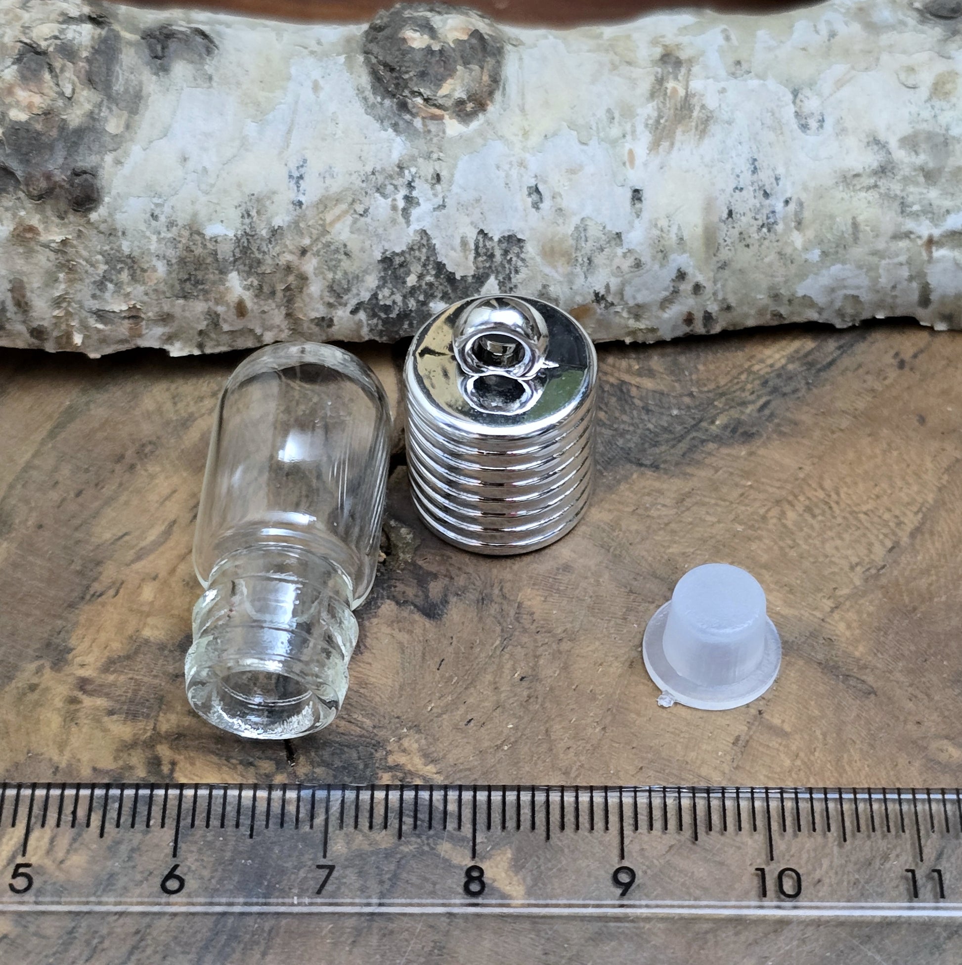 Anhänger Glasflasche mit rundem Boden zum selber befüllen.  Die Glasflasche hat oben eine "große" Öffnung und bietet Platz für eine Vielzahl von Erinnerungen und Materialien wie Edelsteinsplitter, Sand, Glitzer, Granulat, Tierhaare, Milchzähne, kleine Turmdeckelschnecken etc. (bitte beachten Sie die Öffnungsgröße). 