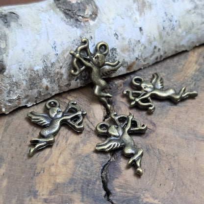 4 Charms Armor in antik bronzefarbig liegend auf einem Holzbrett 