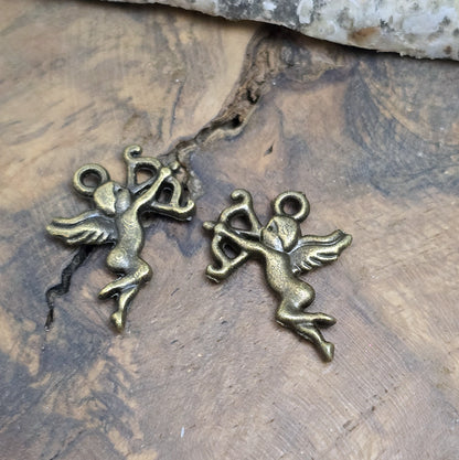 2 Anhänger Armor in bronzefarbig liegend auf Holz, detailaufnahme