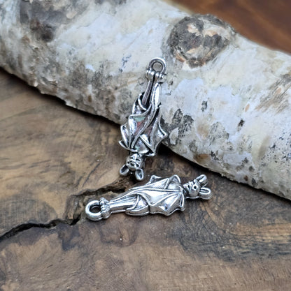 2 antik silberne Charms, hängende Fledermaus in Detailansicht, aus der Perspektive rechts