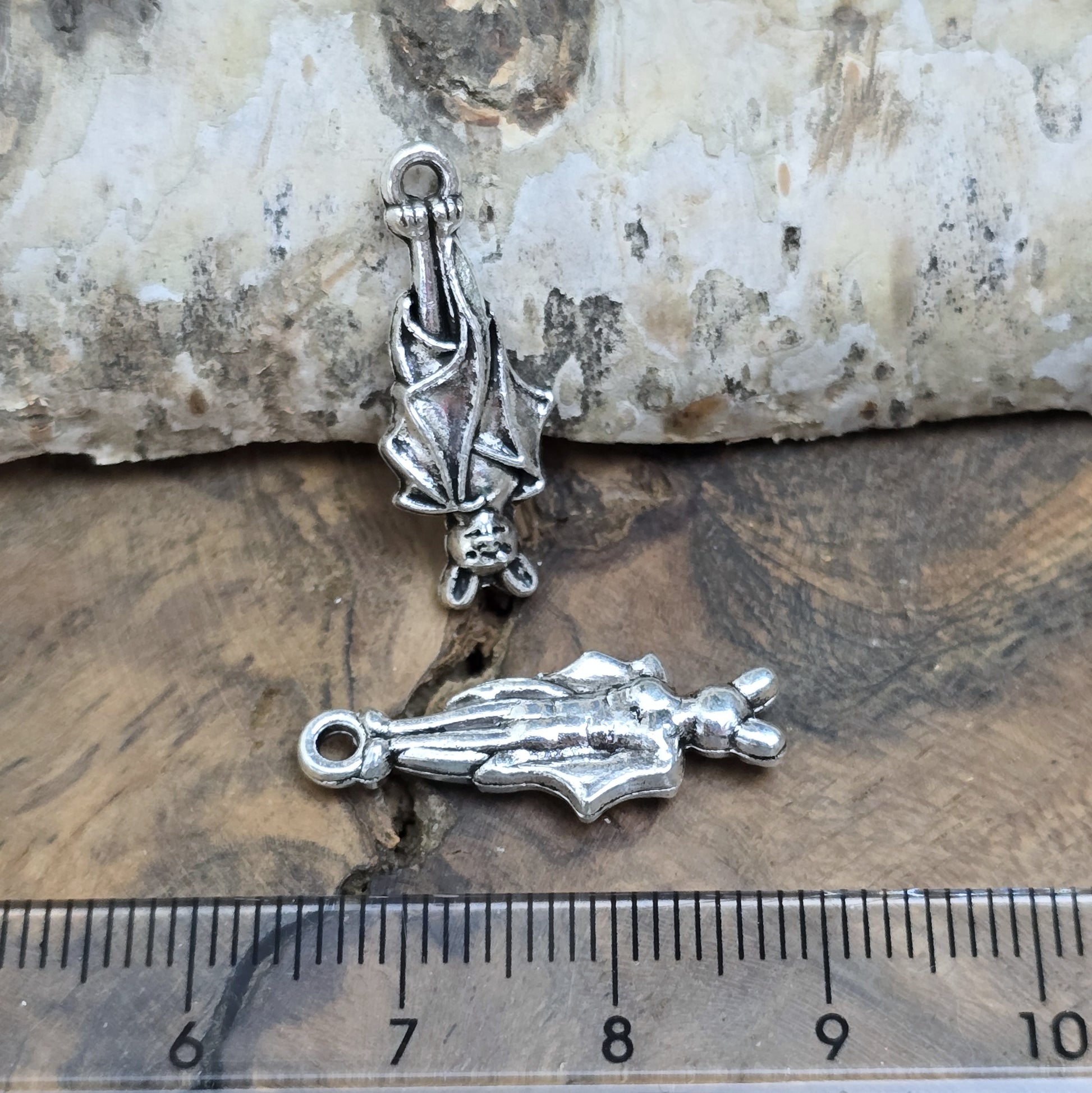 2 antik silberne Charms, hängende Fledermaus in Detailansicht, mit Lineal zur besseren Größenübersicht