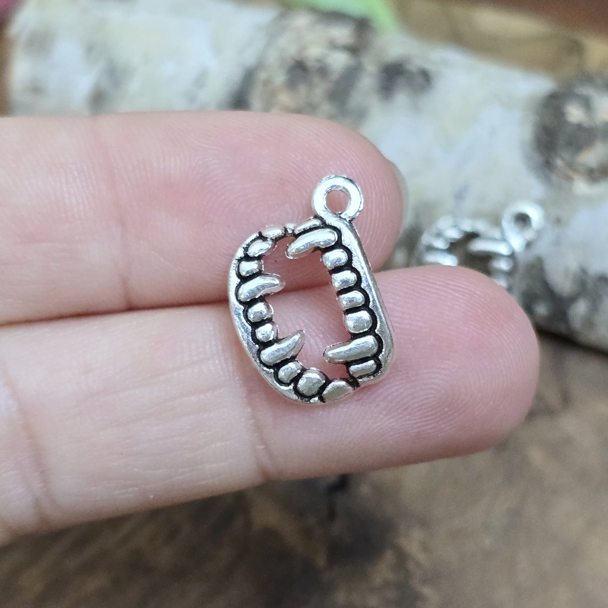 Das Bild zeigt 3 Charms Anhänger Vampirzähne in antik silberfarbig, 18mm. Ideal für die Schmuckherstellung.
