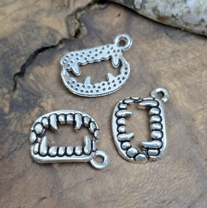 Das Bild zeigt 3 Charms Anhänger Vampirzähne in antik silberfarbig, 18mm. Ideal für die Schmuckherstellung.