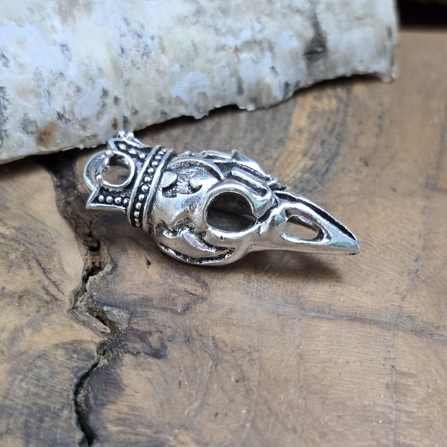 Das Bild zeigt einen Anhänger Krähenschädel, Rabenschädel &nbsp;mit Krone, antik silberfarbig, 33mm

... für einen mystischen und zeitlosen Look.

Der Anhänger hat oben am Schädel eine feste Öse und eignet sich hervorragend für die individuelle Schmuckherstellung.