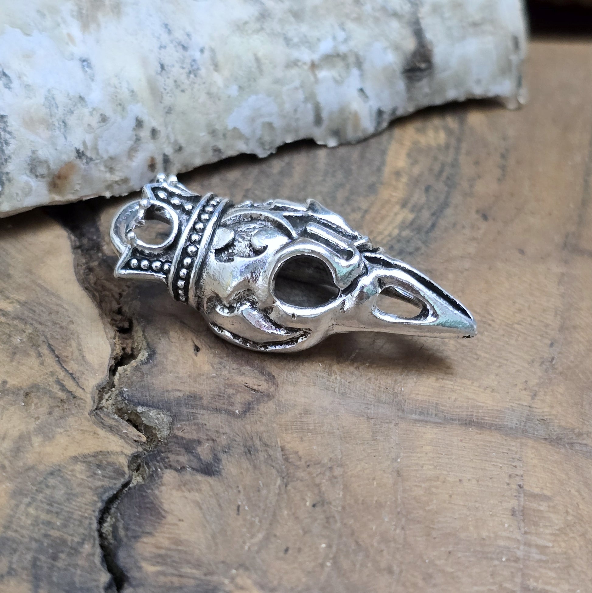Das Bild zeigt einen Anhänger Krähenschädel, Rabenschädel &nbsp;mit Krone, antik silberfarbig, 33mm

... für einen mystischen und zeitlosen Look.

Der Anhänger hat oben am Schädel eine feste Öse und eignet sich hervorragend für die individuelle Schmuckherstellung.