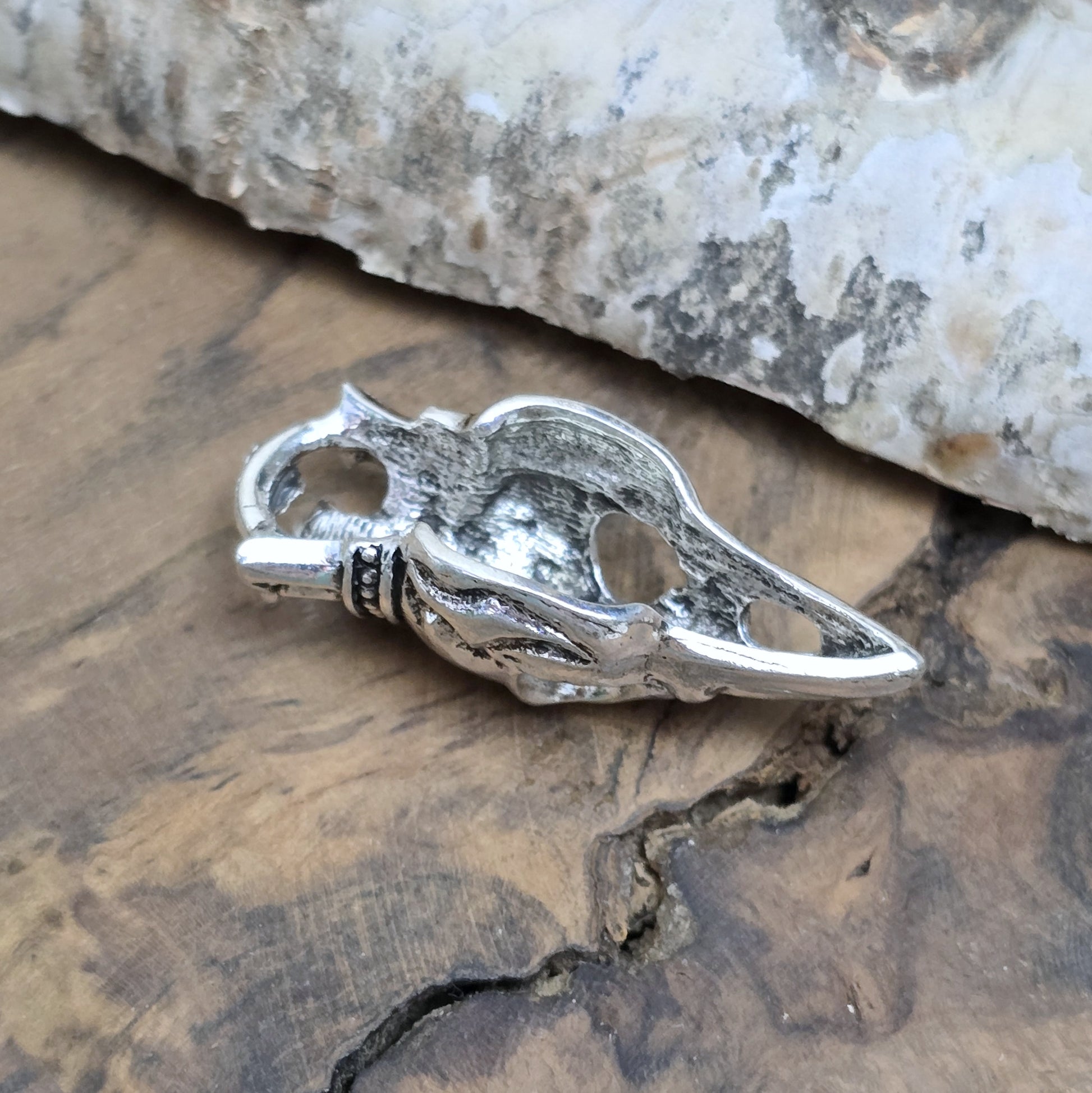 Das Bild zeigt einen Anhänger Krähenschädel, Rabenschädel mit Krone, antik silberfarbig, 33mm

... für einen mystischen und zeitlosen Look.

Der Anhänger hat oben am Schädel eine feste Öse und eignet sich hervorragend für die individuelle Schmuckherstellung.