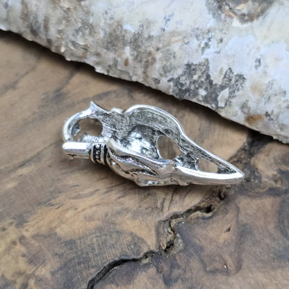 Das Bild zeigt einen Anhänger Krähenschädel, Rabenschädel mit Krone, antik silberfarbig, 33mm

... für einen mystischen und zeitlosen Look.

Der Anhänger hat oben am Schädel eine feste Öse und eignet sich hervorragend für die individuelle Schmuckherstellung.