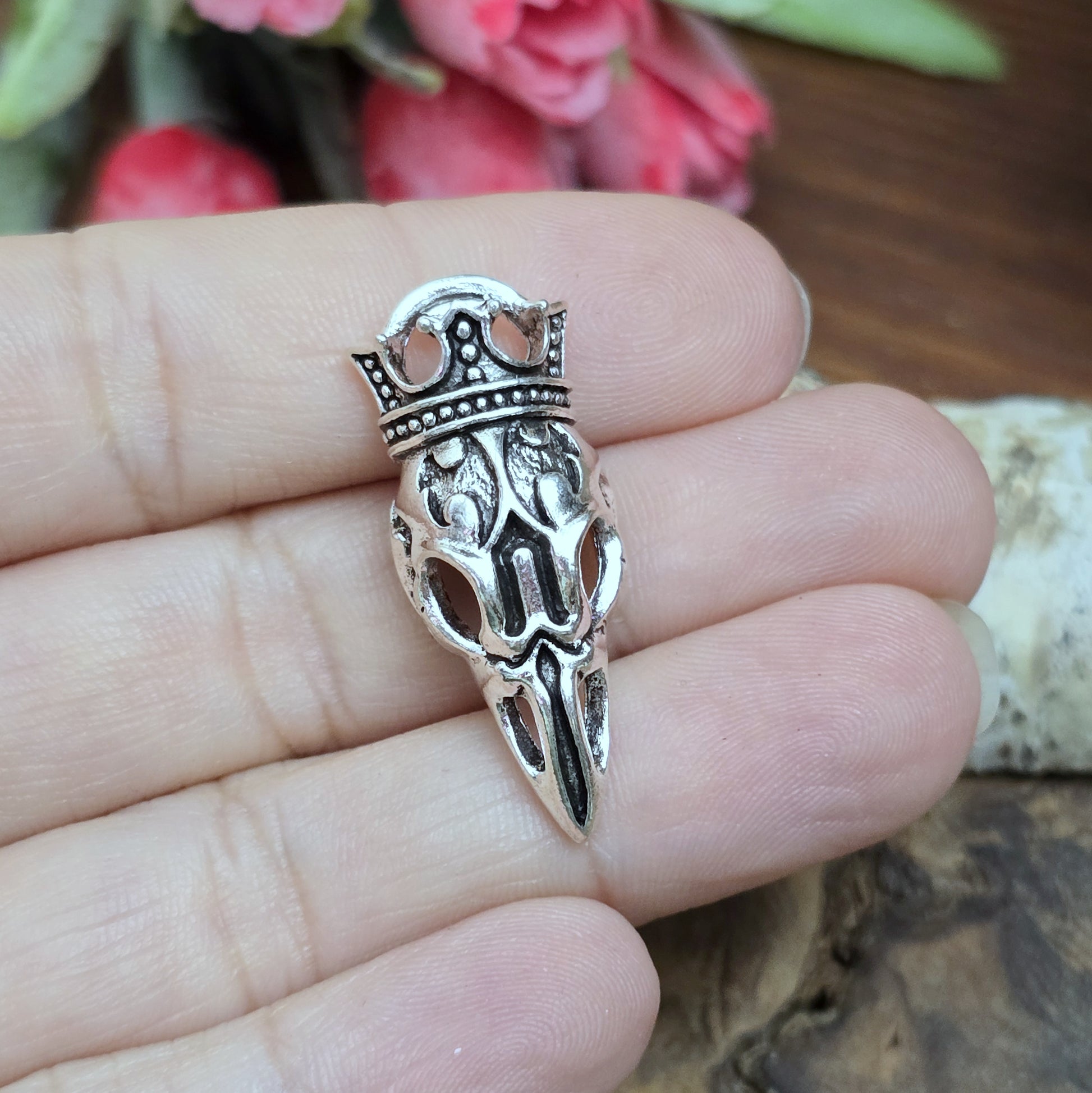 Das Bild zeigt einen Anhänger Krähenschädel, Rabenschädel mit Krone, antik silberfarbig, 33mm

... für einen mystischen und zeitlosen Look.

Der Anhänger hat oben am Schädel eine feste Öse und eignet sich hervorragend für die individuelle Schmuckherstellung.